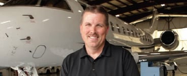 Greg Hamelink Sr. Manager Flight Ops & Maintenance Stryker in Hangar with Aircraft in Background